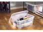 Boîtes de rangement transparentes avec produits d'entretien pour chaussures et chaussures sur une étagère.