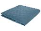 Couverture bleu sarcelle matelassée, motif géométrique.