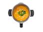 Soupe orange avec croûtons et persil dans un robot culinaire, vue de dessus.