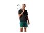 Homme en t-shirt noir et short vert, tenant une raquette de squash et une balle.