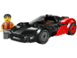Une voiture de sport jouet noire et rouge avec une figurine souriante à côté.