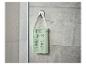Radio de douche vert menthe avec affichage numérique accrochée à un mur carrelé.