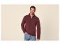 Homme portant un pull bordeaux à fermeture éclair et un jean.