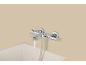 Mitigeur thermostatique de baignoire chromé avec de l'eau qui coule.