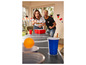 Deux personnes jouent au beer pong avec une balle orange et des gobelets rouges.