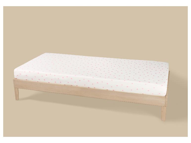 Lit simple en bois clair avec matelas blanc et motif floral rose
