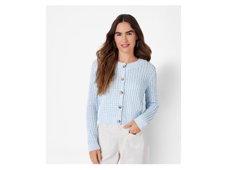 Une femme porte un cardigan en tricot bleu clair à boutons.