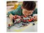 Un enfant joue avec un set Lego Speed Champions Ferrari pit stop.