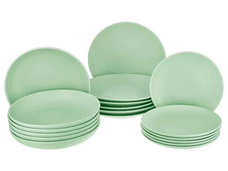 Assortiment de vaisselle vert clair, comprenant des assiettes creuses et plates empilées.