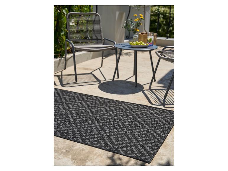 Tapis de couloir extérieur noir et gris sur une terrasse avec mobilier de jardin.