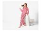 Une femme en pyjama rose à motifs cœurs