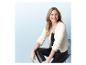 Femme portant un cardigan blanc et un pantalon en simili cuir noir.