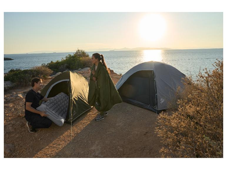 Deux tentes Crivit et un matelas de camping sur une côte ensoleillée.