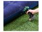 Pompe à air électrique gonflant un matelas gonflable bleu sur de l'herbe verte.