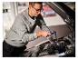 Homme utilisant la lampe de travail LIVARNO® 'The Mechanic' pour éclairer le moteur de la voiture.