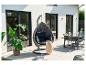 Patio moderne avec un fauteuil suspendu, un ensemble de salle à manger et une grande plante en pot.