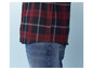 Une chemise à carreaux rouge et noir à manches longues et un jean bleu.
