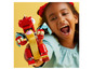 Un enfant tient un dragon LEGO rouge