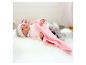 Poupée Baby Annabell en pyjama rose et couverture sur fausse fourrure blanche.