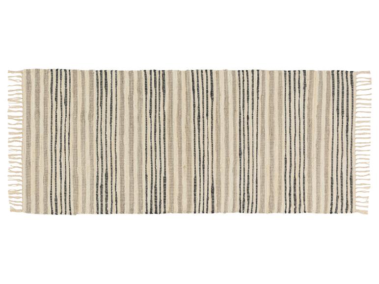 Un tapis tissé avec des rayures noires et beiges et des franges.