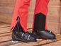 Pantalon de ski rouge avec des chaussures de ski noires.