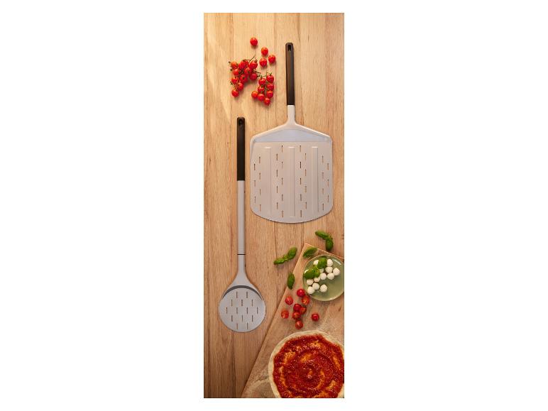 Pelles à pizza avec tomates cerises, mozzarella, basilic et base de pizza sur une planche en bois.