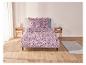 Un lit avec des draps à motifs paisley et deux tables de chevet.