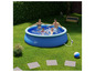 Une piscine gonflable Livarno Home dans le jardin avec quatre personnes qui nagent dedans.