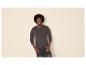 Homme avec afro portant un t-shirt Henley gris foncé à manches longues et un jean foncé.
