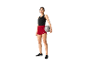 Femme tenant un ballon et portant un short rouge.