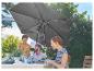 Parasol de jardin et amis partageant un repas en extérieur.
