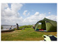 Une tente Grand Canyon verte sur un camping au bord de l'eau.