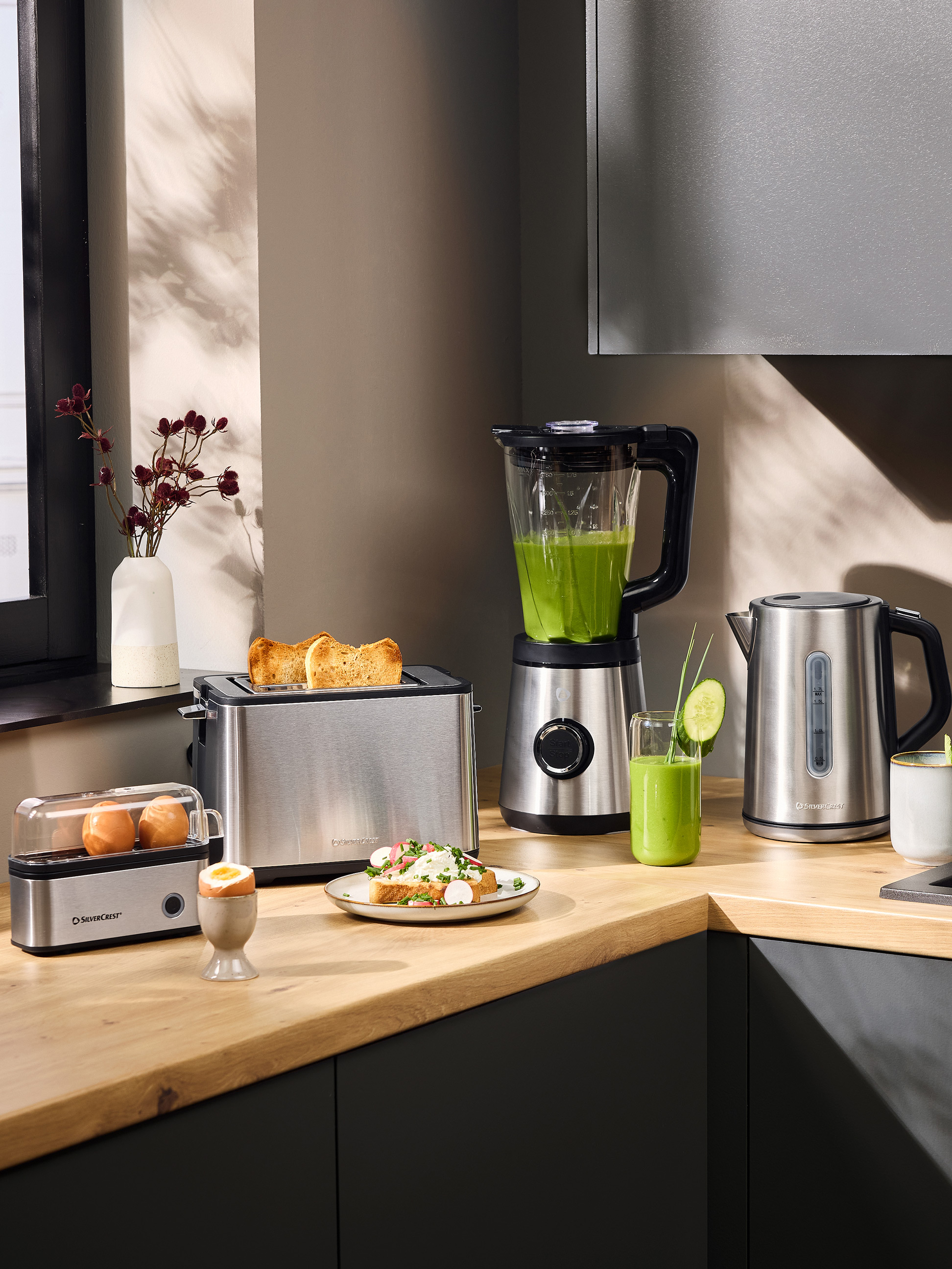 Grille-pain, mixeur et bouilloire électrique dans une cuisine moderne avec petit-déjeuner.