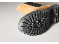 Gros plan sur la semelle noire crantée d'une botte en daim beige.