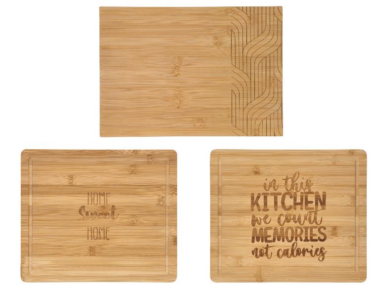 Trois planches à découper en bambou, une avec un motif géométrique et deux avec des messages gravés.