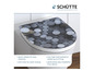 Une cuvette de toilettes blanche avec un motif rond gris, de la marque Schütte.