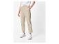 Femme en pantalon beige et baskets blanches.