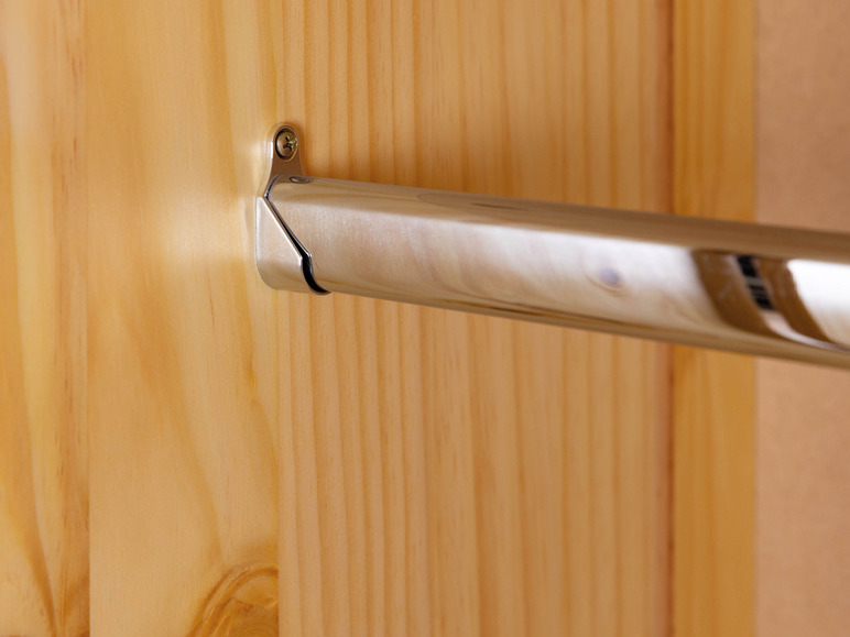 Une tringle à vêtements argentée fixée à une armoire en bois.