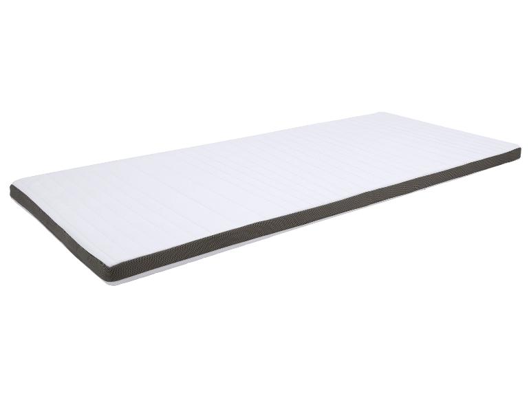 Surmatelas blanc avec bordure grise, vu en angle.