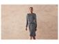Une femme portant une robe en tricot grise avec une ceinture.