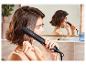Une femme se lisse les cheveux avec un lisseur Silvercrest.