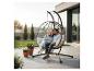 Couple se relaxant dans un fauteuil suspendu œuf sur une terrasse avec jardin.