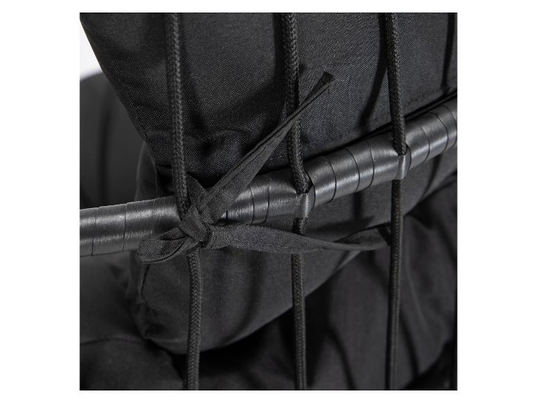 Gros plan d'une housse de coussin noire attachée à une chaise avec des cordes.