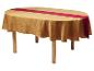 Table ovale avec nappe dorée à motifs et chemin de table rouge