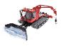 Dameuse rouge PistenBully 600 avec lame de chasse-neige et bras de levage.