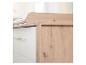 Commode à langer en bois clair et blanc avec poignées métalliques.