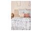 Drap-housse en jersey microfibre LIVARNO home sur un lit beige avec parure de lit fleurie.