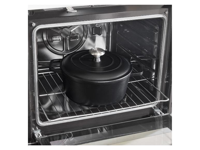 Cocotte en fonte noire dans un four sur une grille.