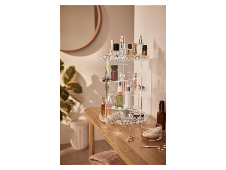 Un organisateur de maquillage rotatif en acrylique rempli de divers produits de beauté.