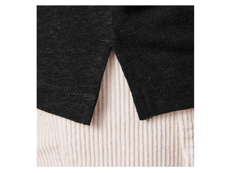 Gros plan sur un t-shirt noir en coton et un pantalon en velours côtelé beige.